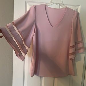 Light pink top. Flowy sleeves with mesh detail.